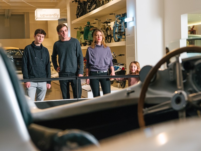 Drei Jugendliche vor einem Auto in der Ausstellung "Mobilität": 
