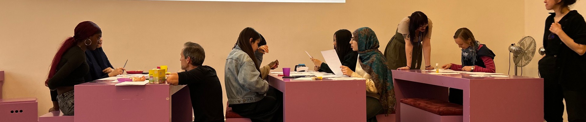 Young people work in groups at tables in front of a projected question “Space for all!?” at the Technisches Museum Wien.: Time to reflect: the Planet Hunters are considering how space can become more accessible for everyone and what other obstacles exist.
