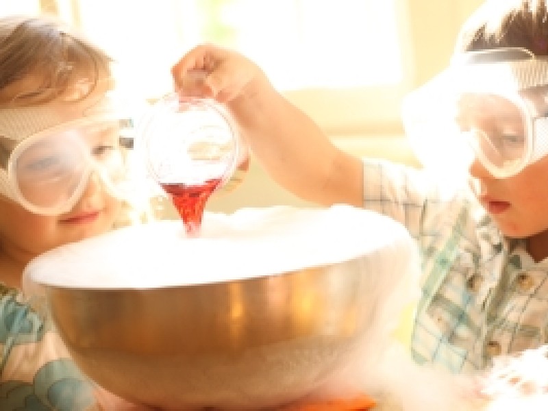 : Kinder mit Schutzbrillen bei einem chemischen Experiment