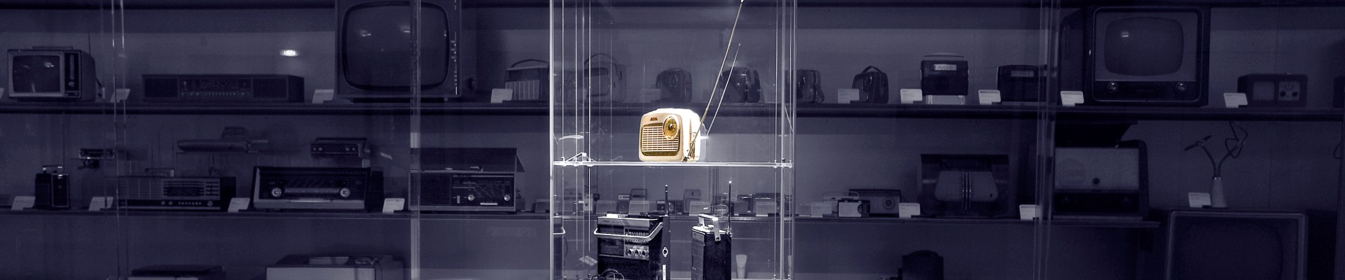 Schwarz-weiß Foto von Glasschrank mit Objekt (gelbes Transistorradio): 