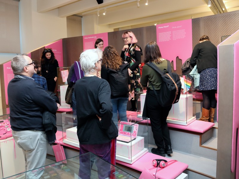 Besucher beim Betrachtung von Ausstellungsobjekten der "Wem gehört Pink?" Ausstellung: Besucher beim Betrachtung von Ausstellungsobjekten