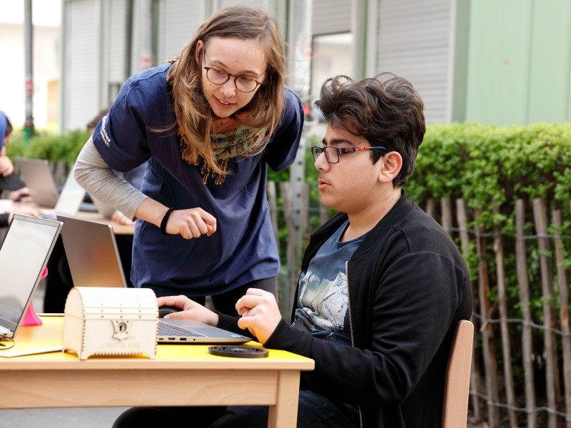 Explainer explains a computer program to a student: The participants are accompanied by explainers through all production steps.