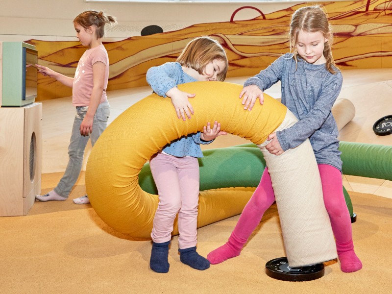 Kinder spielen im Kinderbereich "miniXplore" an der Station "Kabelsalat": 