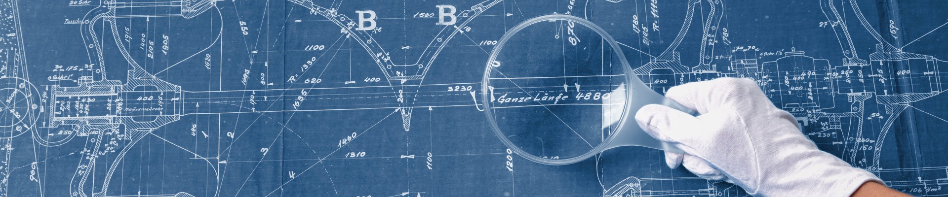 Hand with white glove and magnifying glass over a blueprint of a turbine from the estate of Viktor Kaplan: 