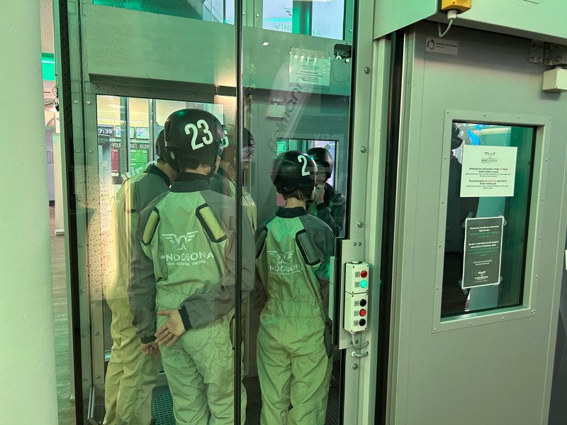 : Gleich geht es los! Die Gruppe zukünftiger Windkanalflieger:innen wartet aufgeregt auf ihren ersten Flug.