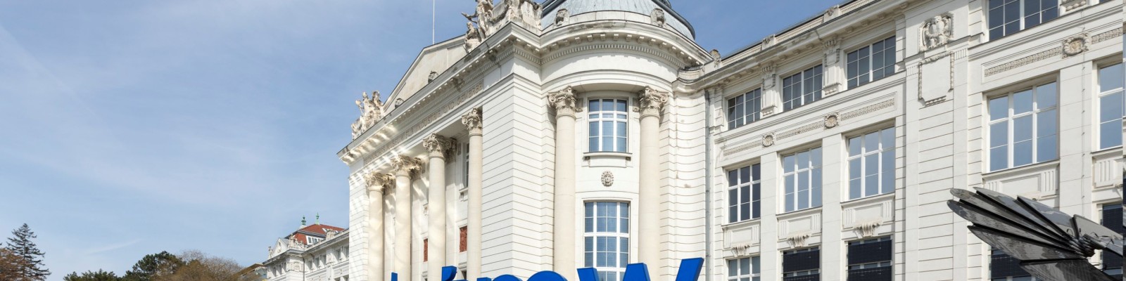 Fassade des Technischen Museums Wien mit blauem tmw-Logo im Vordergrund