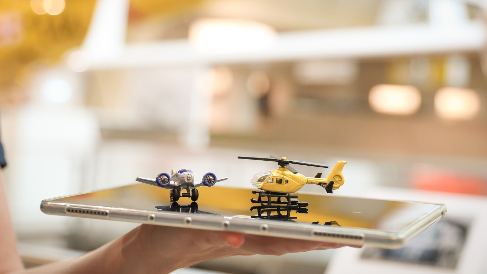Ein Spielzeug-Hubschrauber und ein Spielzeug-Flugzeug auf einem Tablett: 