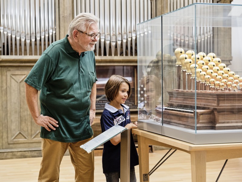 Mann und Kind vor der Orgel in der Ausstellung "Musikinstrumente": 
