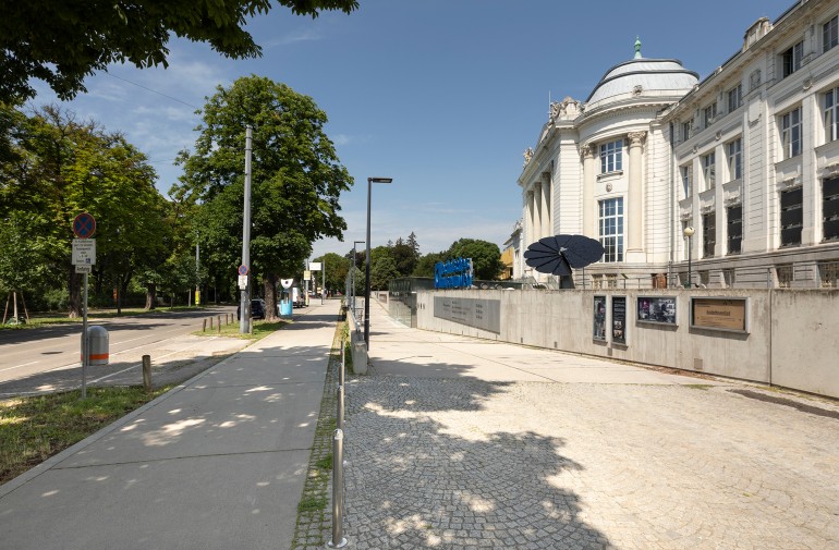 Foto des Technischen Museums Wien mit Straße und Gehsteig: 
