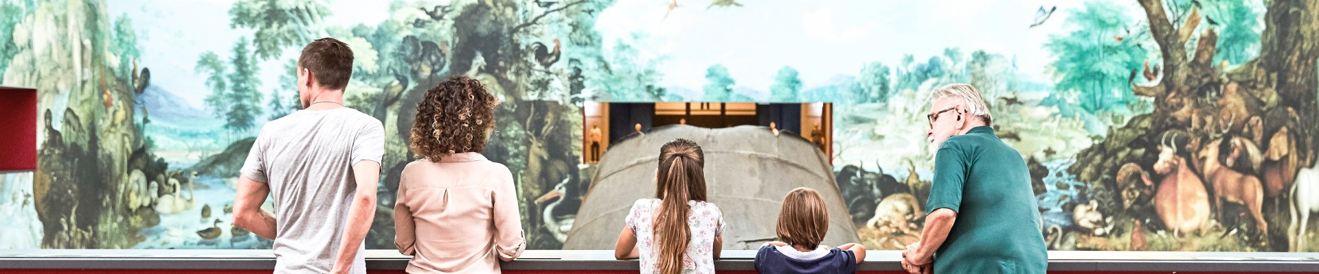 Familie betrachtet Wandbild "Paradies" aus der Ausstellung "In Arbeit": 