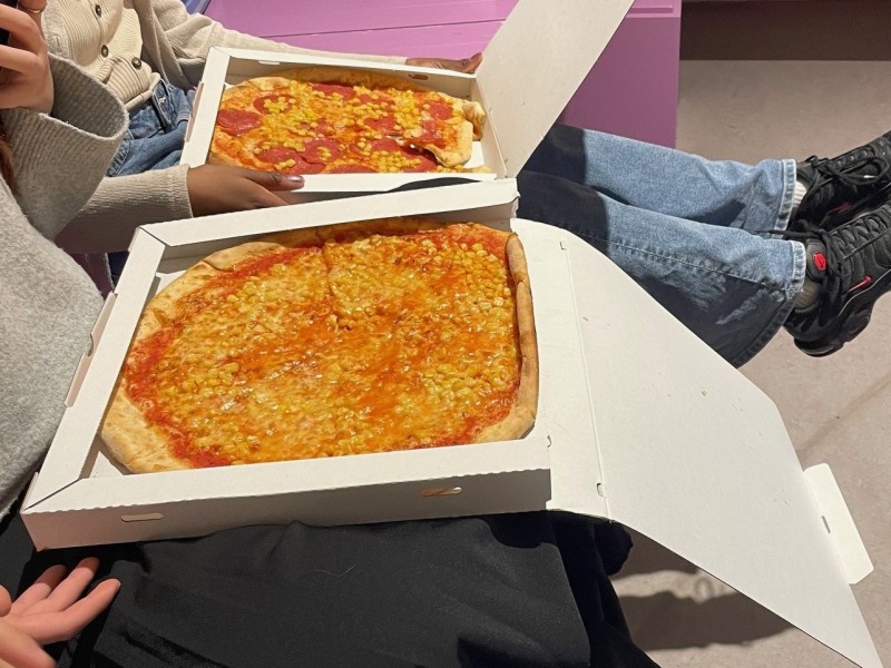 : Alle haben ihre Pizza und machen es sich gemütlich.
