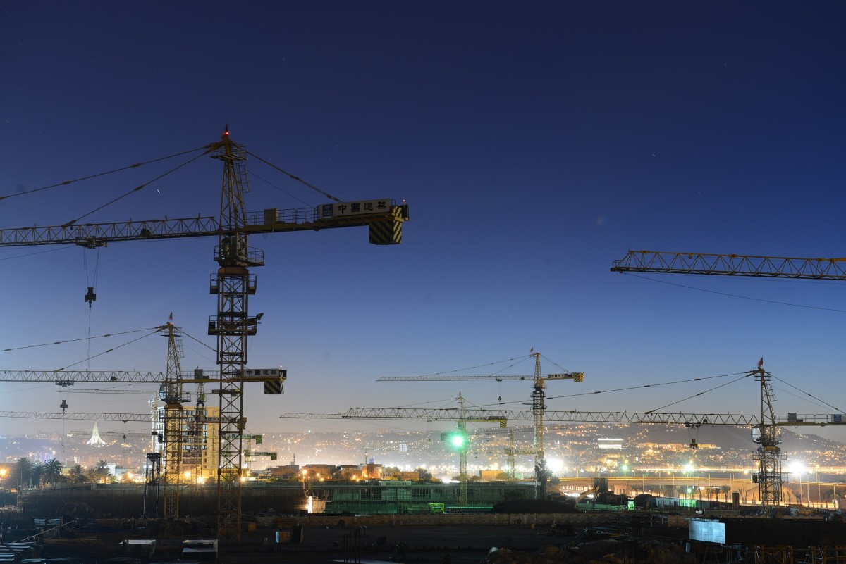 Eine nächtliche Stadtsilhouette mit mehreren Baukränen: Die stählernen Giganten in der modernen Stadtsilhouette stehen sinnbildlich für Wandel, Technik und urbane Entwicklung