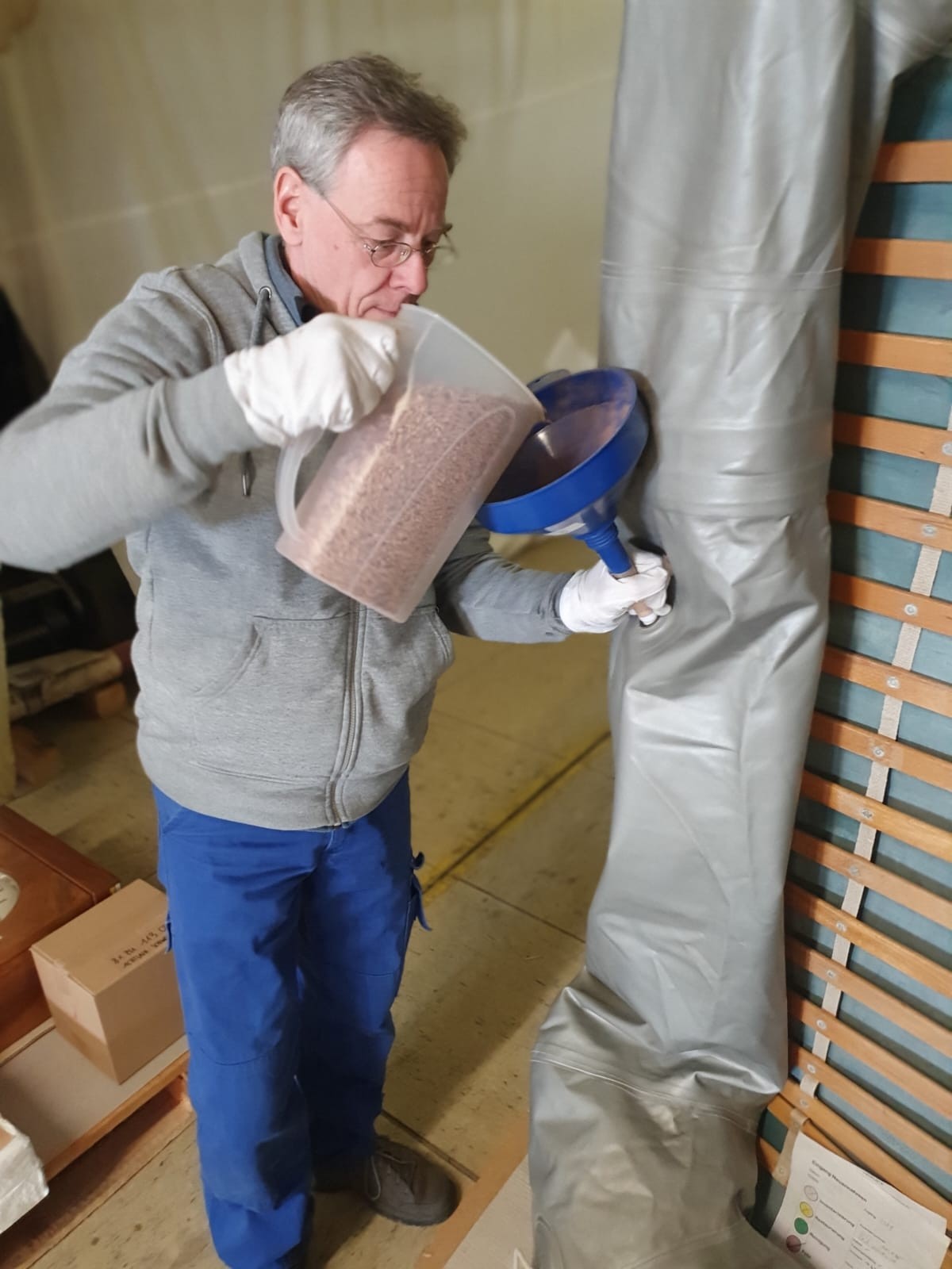 Ein Mitarbeiter des Museums befüllt ein Schlauchboot mit Naturkorkgranulat: Befüllung des Schlauchboots mit Naturkorkgranulat