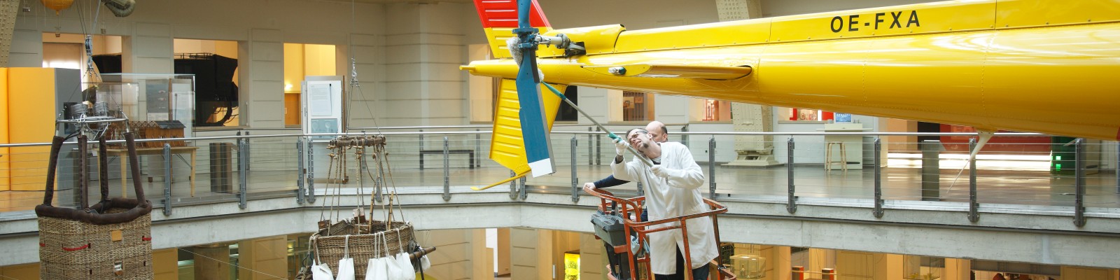 Members of the restauration department’s staff cleaning the ÖAMTC’s (Austrian motoring association) rescue helicopter using an aerial work platform / Object cleaning in the collection on display