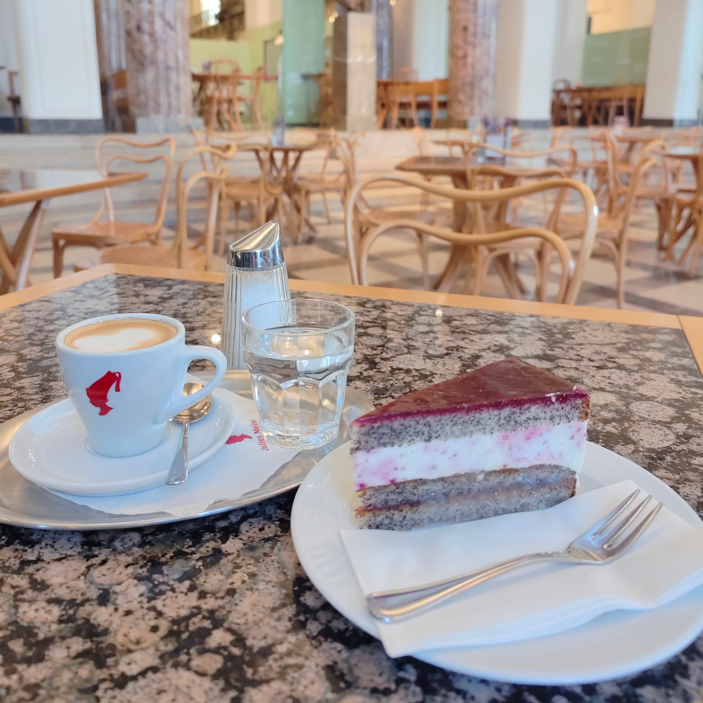 A cake and a coffee at a table in the Joules Bistro: 